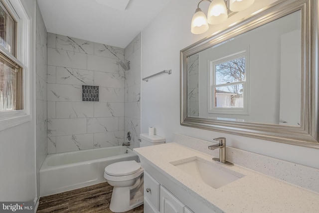 full bathroom featuring tiled shower / bath, vanity, toilet, and wood-type flooring