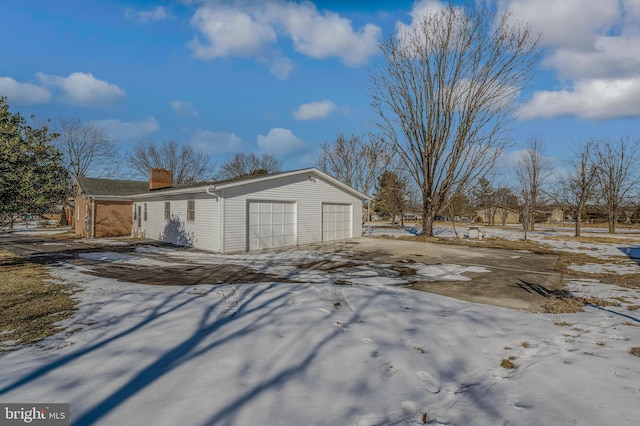 snow covered property featuring a garage