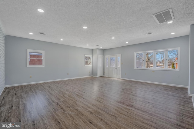 empty room with wood-type flooring and a textured ceiling