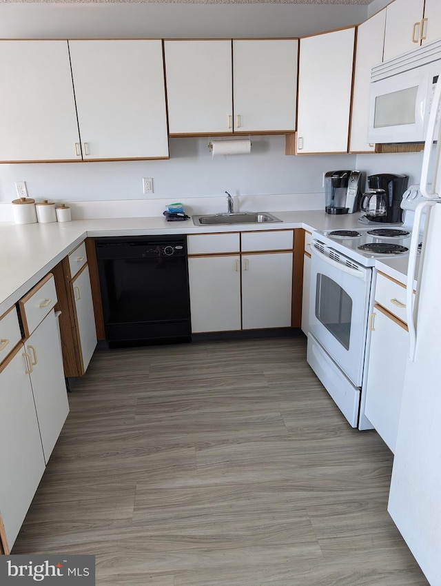 kitchen featuring sink, white appliances, white cabinets, and light wood-type flooring