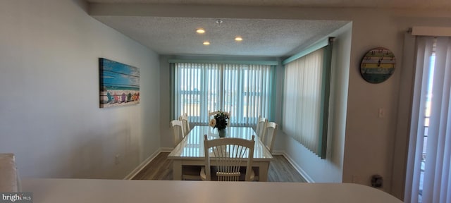 dining room with wood-type flooring and a textured ceiling