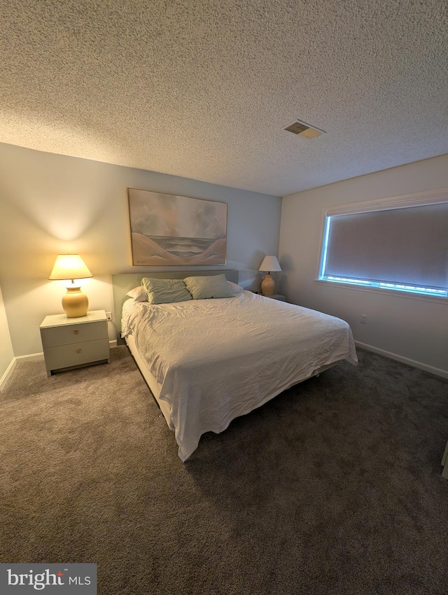 bedroom with carpet floors and a textured ceiling