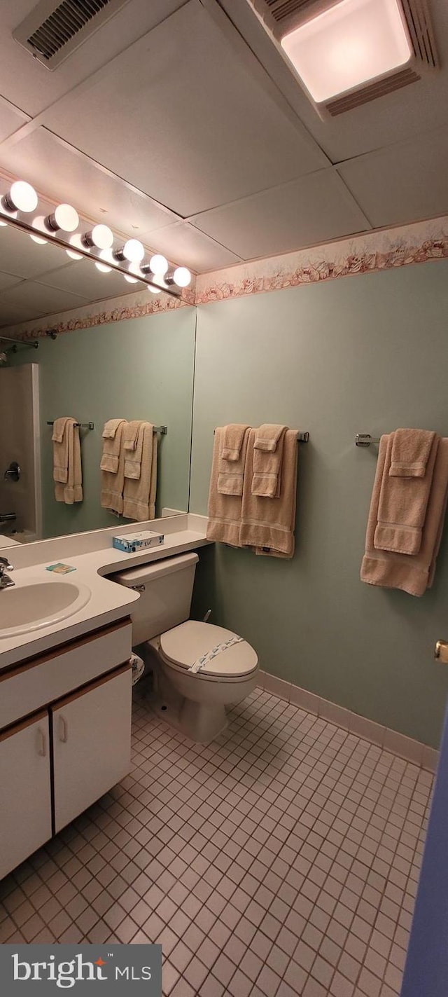 bathroom with tile patterned flooring, vanity, walk in shower, and toilet