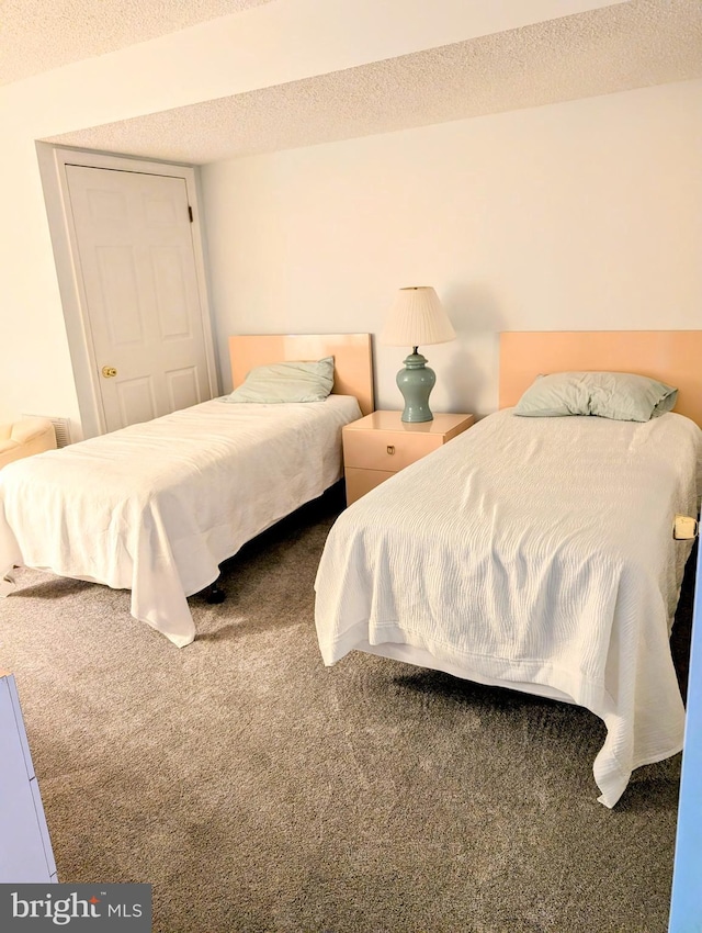 bedroom featuring carpet floors and a textured ceiling