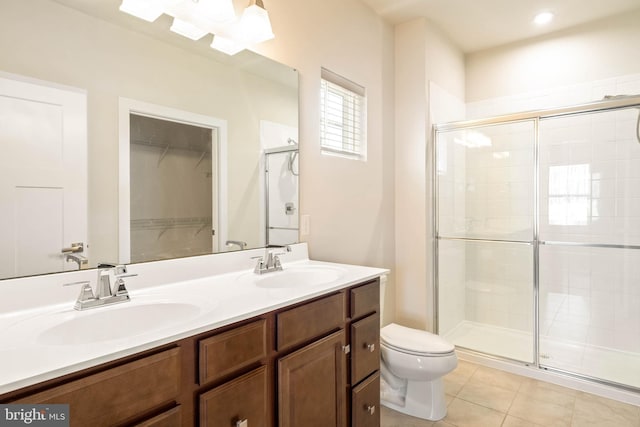 bathroom with tile patterned flooring, vanity, toilet, and a shower with shower door