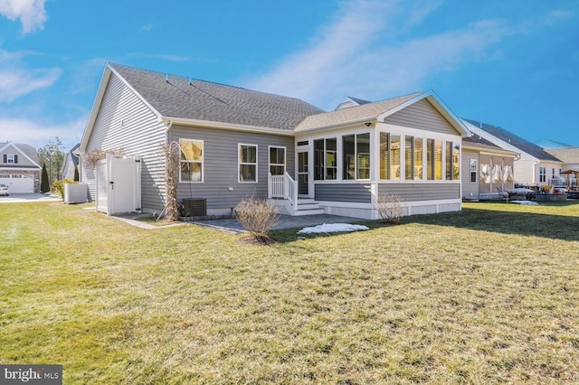 back of property featuring a sunroom and a yard