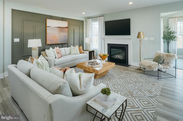 living room with light hardwood / wood-style floors and a healthy amount of sunlight