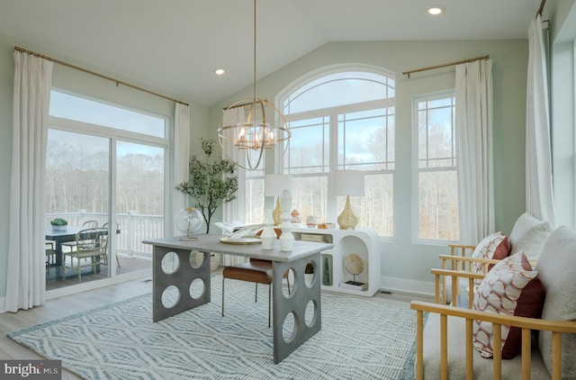 dining area with vaulted ceiling, a notable chandelier, and light wood-type flooring