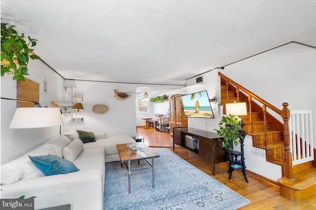 living room featuring hardwood / wood-style flooring and ceiling fan