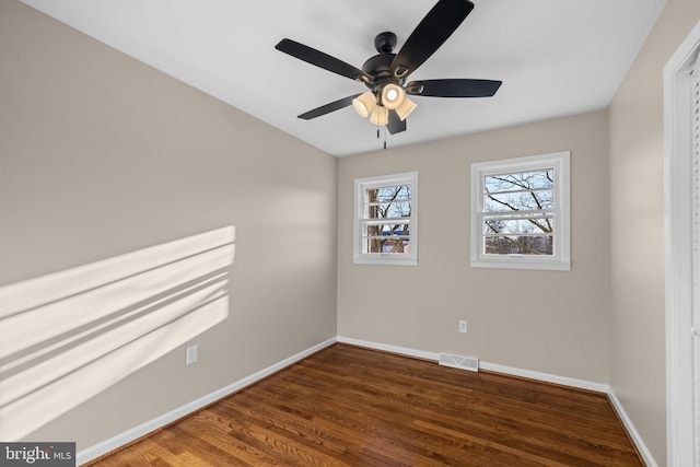 empty room featuring dark wood-type flooring and ceiling fan