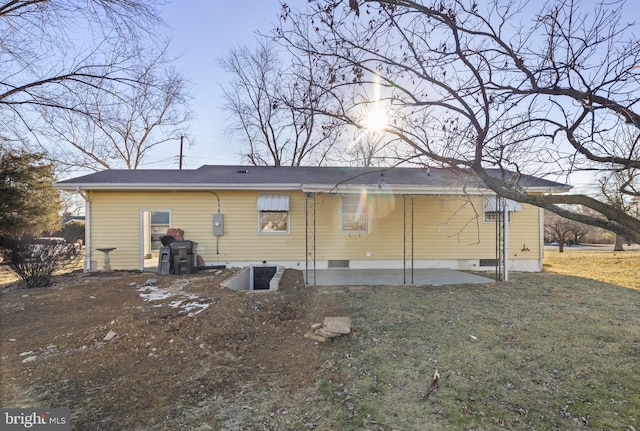 back of property featuring a patio and a lawn