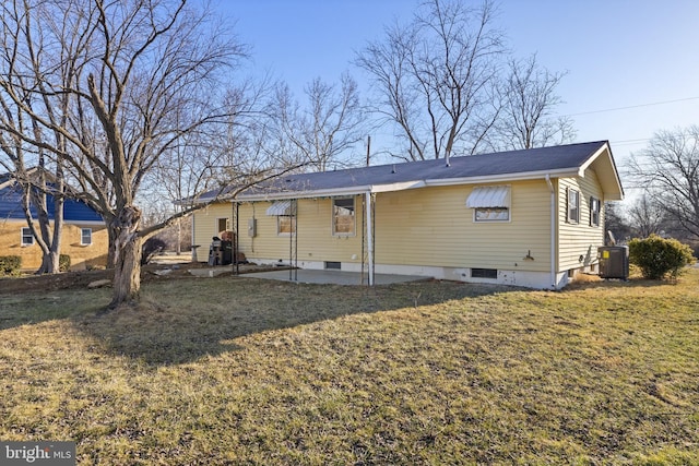 back of property with central AC unit, a lawn, and a patio