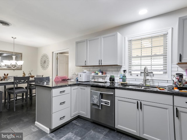 kitchen featuring decorative light fixtures, sink, decorative backsplash, stainless steel dishwasher, and kitchen peninsula