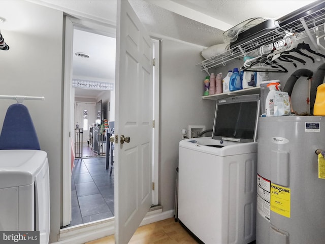 clothes washing area featuring washer and clothes dryer and electric water heater