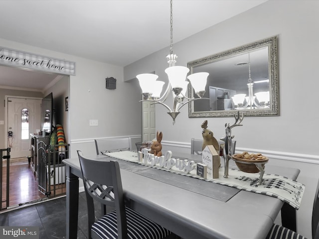 dining room with an inviting chandelier and crown molding