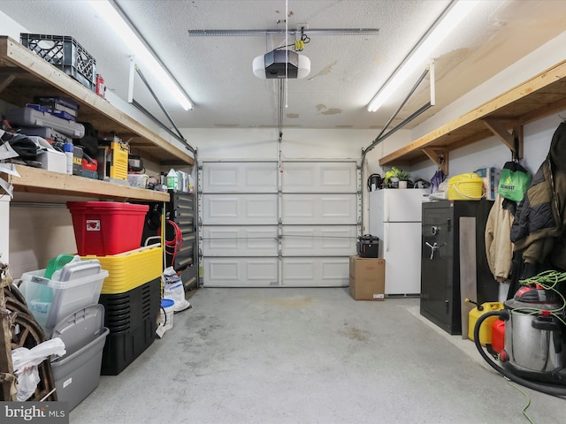 garage with a garage door opener and white fridge