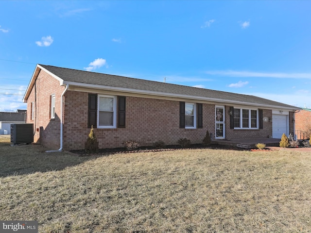 ranch-style home with a garage, central AC, and a front yard