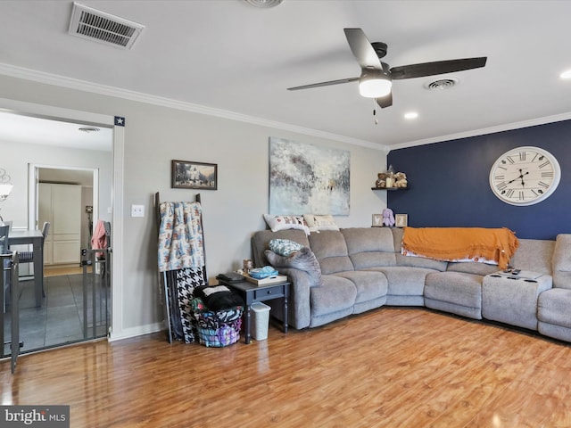 living room featuring hardwood / wood-style flooring, crown molding, and ceiling fan