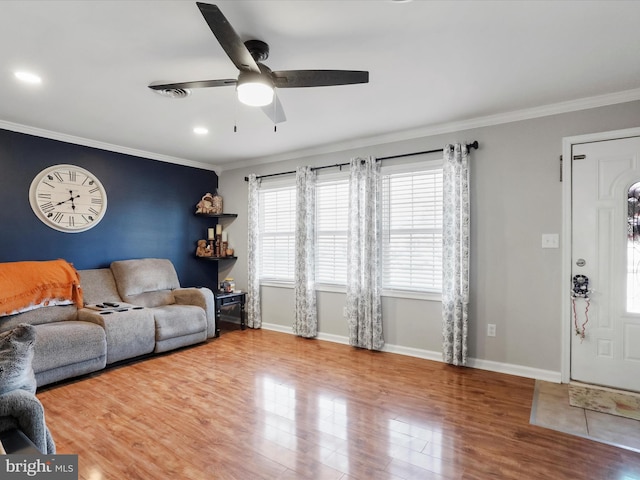 living room with crown molding, wood-type flooring, and ceiling fan