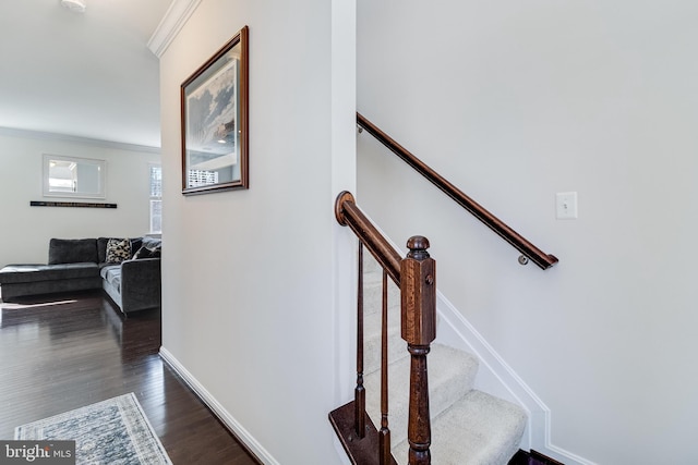 stairs featuring crown molding, baseboards, and wood finished floors