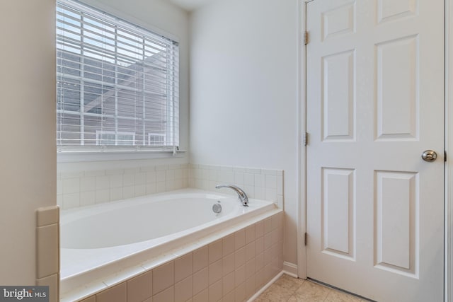 full bath with a healthy amount of sunlight, a bath, and tile patterned floors