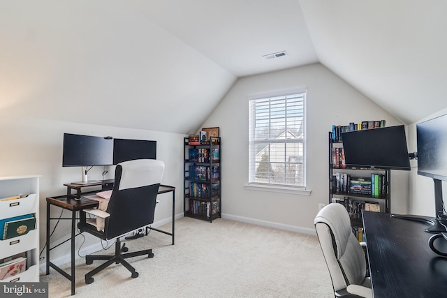 office featuring light colored carpet, visible vents, vaulted ceiling, and baseboards