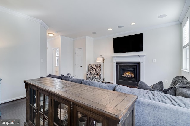 living area with baseboards, dark wood-style floors, ornamental molding, a lit fireplace, and recessed lighting