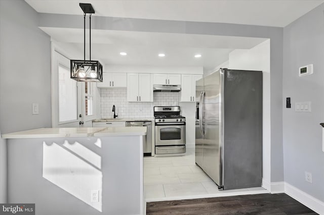 kitchen with white cabinetry, hanging light fixtures, backsplash, stainless steel appliances, and kitchen peninsula