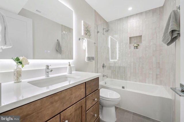 full bathroom with tiled shower / bath, vanity, toilet, and tile patterned floors