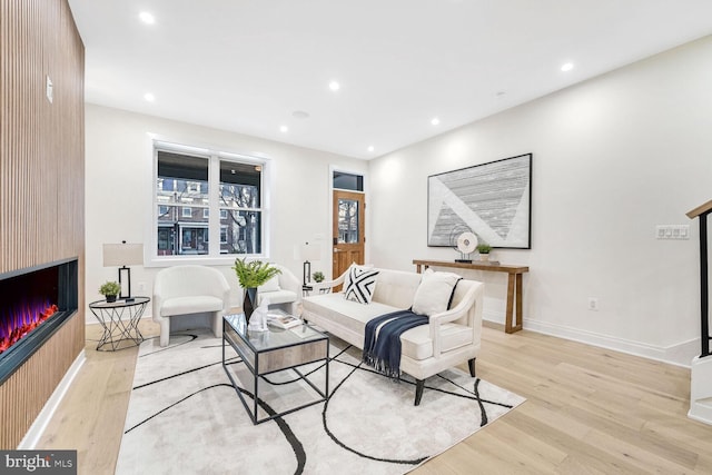 living room featuring light hardwood / wood-style flooring and a large fireplace