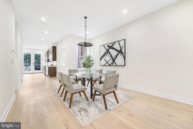 dining area featuring light wood-type flooring and french doors