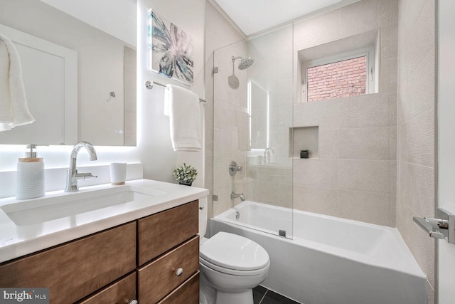 full bathroom featuring tiled shower / bath combo, vanity, and toilet