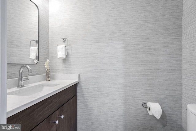 bathroom featuring vanity, tile walls, and toilet