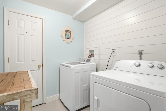 laundry area featuring independent washer and dryer and wood walls