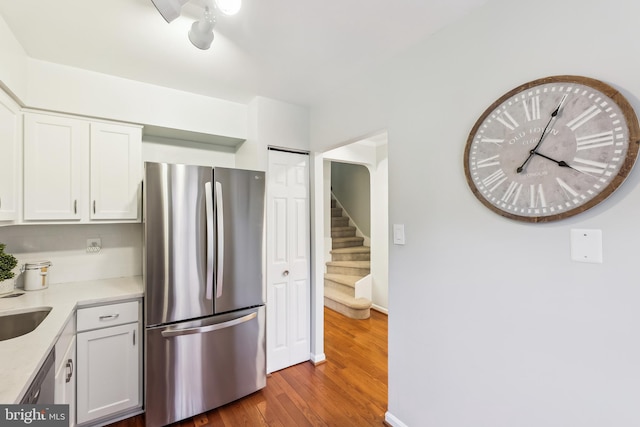 kitchen with hardwood / wood-style flooring, appliances with stainless steel finishes, sink, and white cabinets