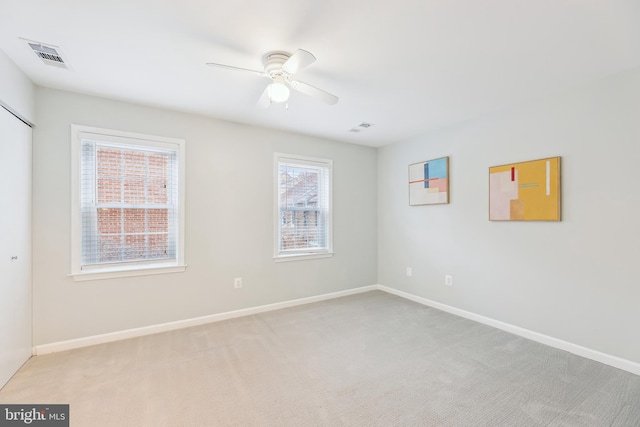 unfurnished room featuring light colored carpet and ceiling fan