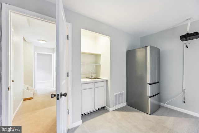 laundry area with light carpet and sink