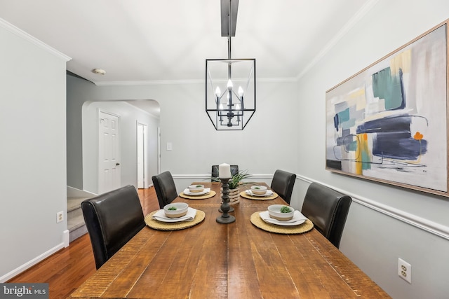 dining room featuring hardwood / wood-style flooring, crown molding, and a chandelier