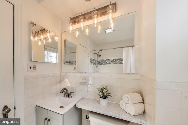 bathroom featuring vanity, curtained shower, and tile walls