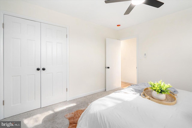 carpeted bedroom featuring ceiling fan and a closet