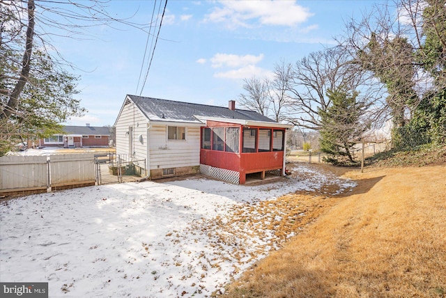 rear view of property featuring a sunroom