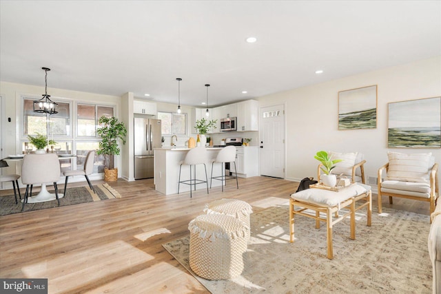 living room featuring a notable chandelier and light wood-type flooring