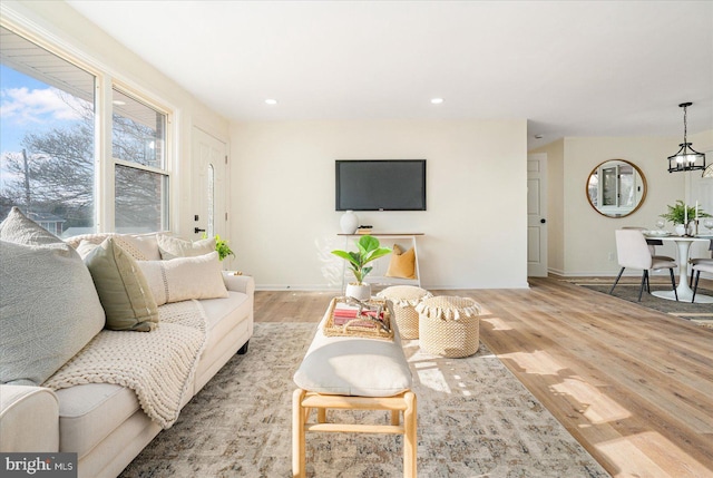 living room featuring a chandelier and light wood-type flooring