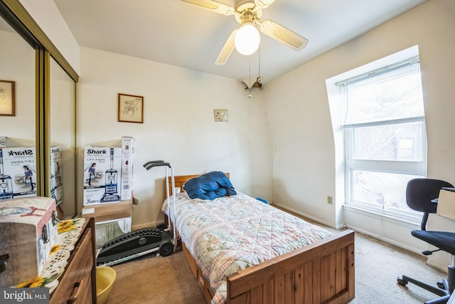 carpeted bedroom featuring ceiling fan and a closet