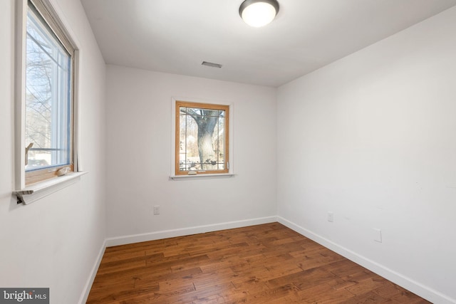 empty room with dark hardwood / wood-style flooring