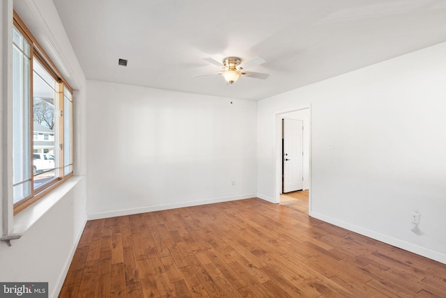 empty room with ceiling fan and light hardwood / wood-style flooring