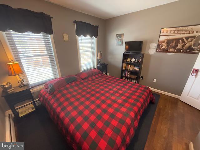 bedroom with dark hardwood / wood-style floors