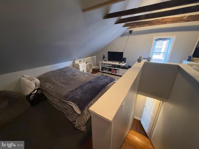 bedroom with vaulted ceiling with beams