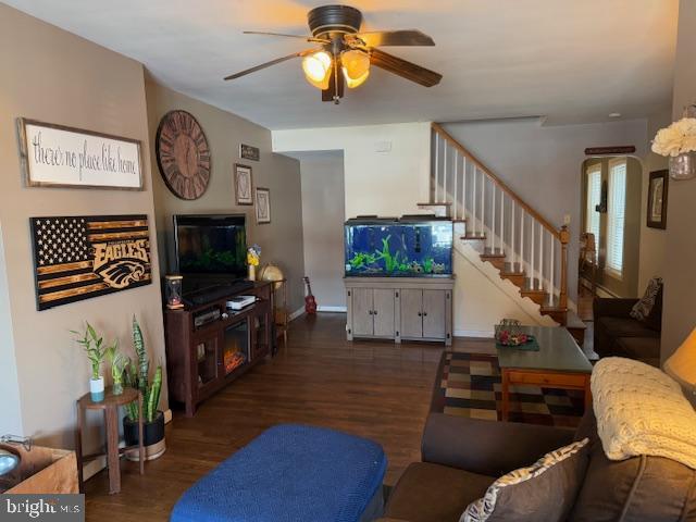 living room with dark wood-type flooring and ceiling fan