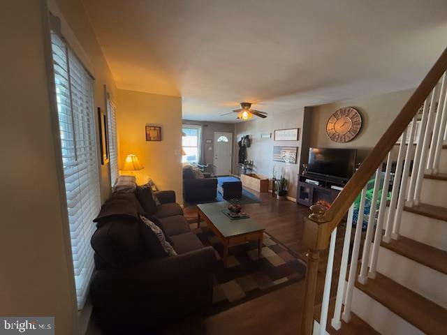 living room featuring wood-type flooring and ceiling fan